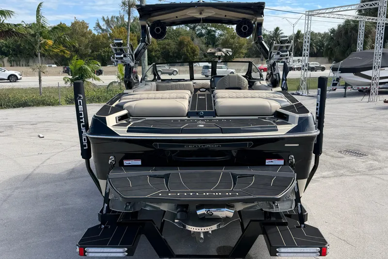 Slide: The Image of 2026 Centurion Ri230 boat with sleek design and luxurious seating, parked outdoors. - 8