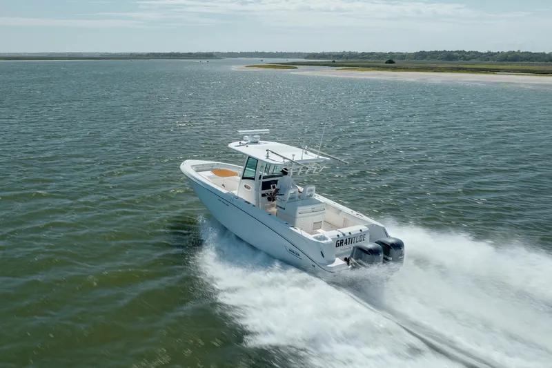 Slide: The Image of 2013 Boston Whaler 320 Outrage cruising on open water, showcasing speed and elegance. - 10