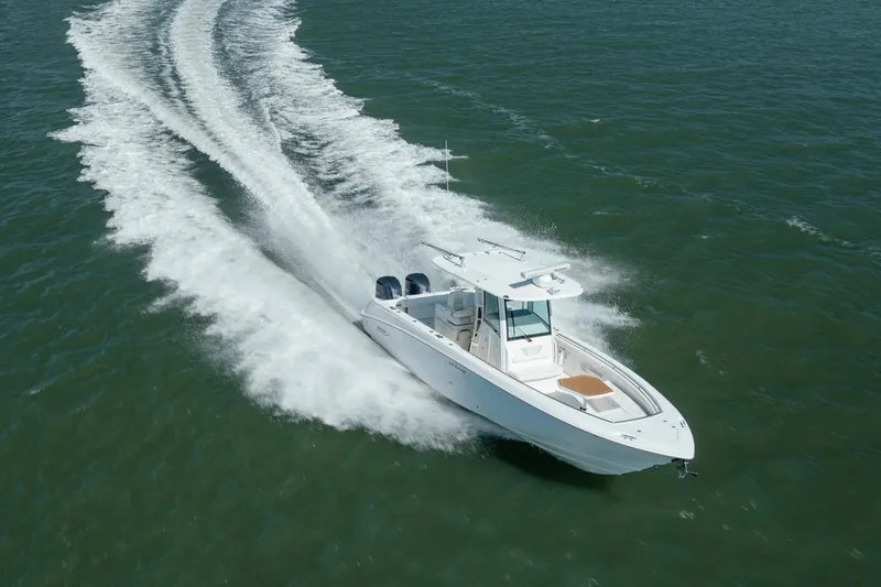 Slide: The Image of 2013 Boston Whaler 320 Outrage cruising on open water, creating a dynamic wake. - 14