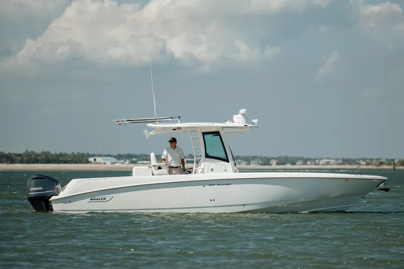 Slide: The Image of 2013 Boston Whaler 320 Outrage boat cruising on calm waters under cloudy skies. - 15