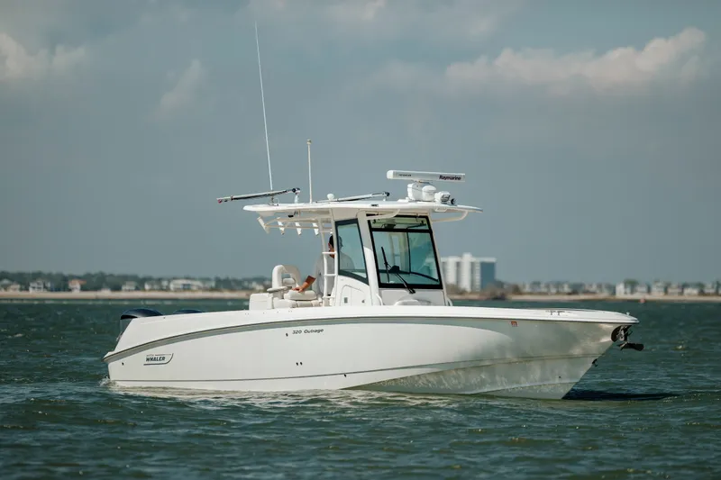 Slide: The Image of 2013 Boston Whaler 320 Outrage boat cruising on open water. - 16