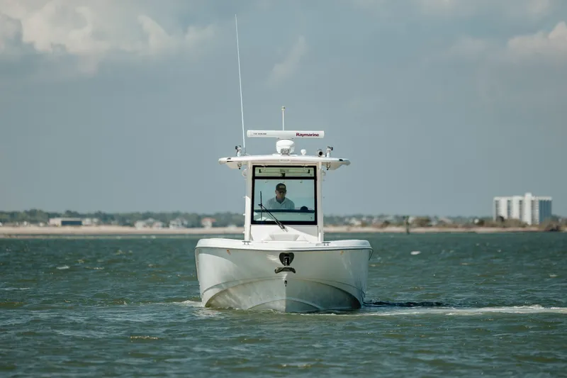 Slide: The Image of 2013 Boston Whaler 320 Outrage boat cruising on open water under cloudy skies. - 17