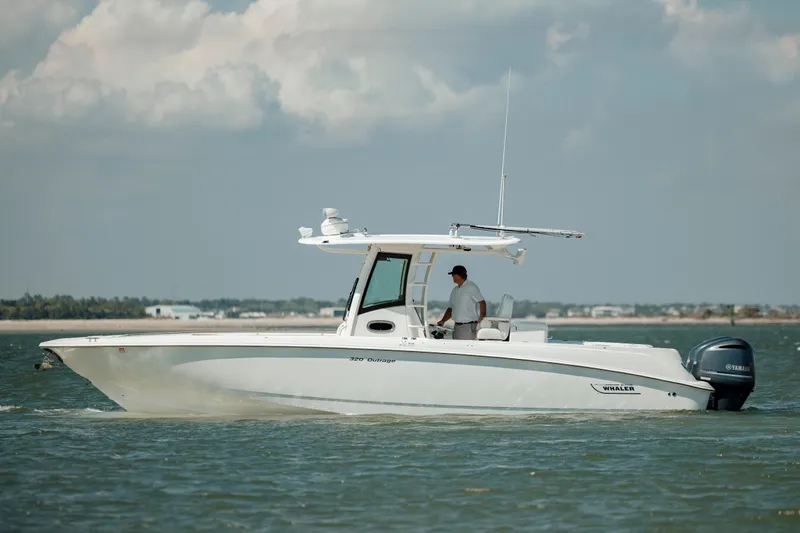 Slide: The Image of 2013 Boston Whaler 320 Outrage boat cruising on open water under cloudy skies. - 19