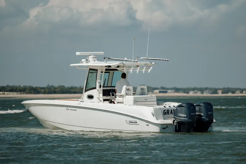 Slide: The Image of 2013 Boston Whaler 320 Outrage boat cruising on open water with twin Yamaha engines. - 20