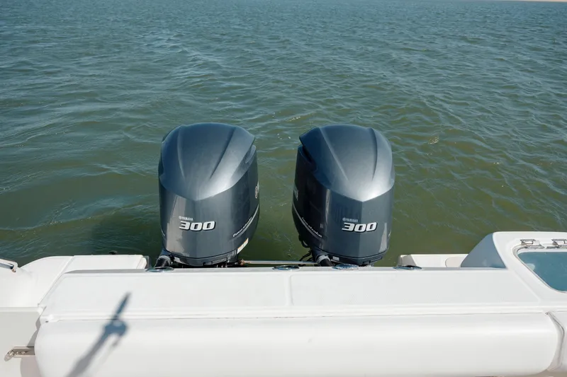 Slide: The Image of Twin Yamaha 300 engines on a 2013 Boston Whaler 320 Outrage boat in open water. - 24