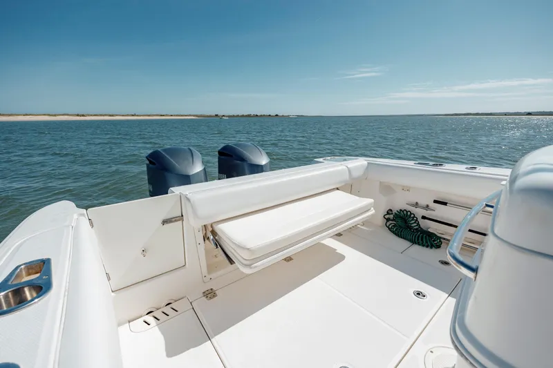 Slide: The Image of 2013 Boston Whaler 320 Outrage boat interior with ocean view, featuring dual engines. - 26