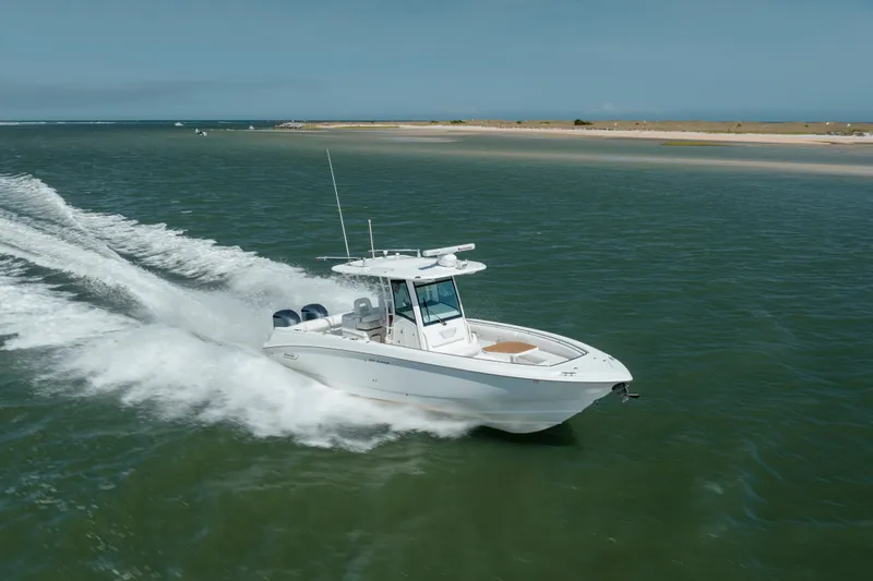 Slide: The Image of 2013 Boston Whaler 320 Outrage cruising on open water, showcasing sleek design and performance. - 3