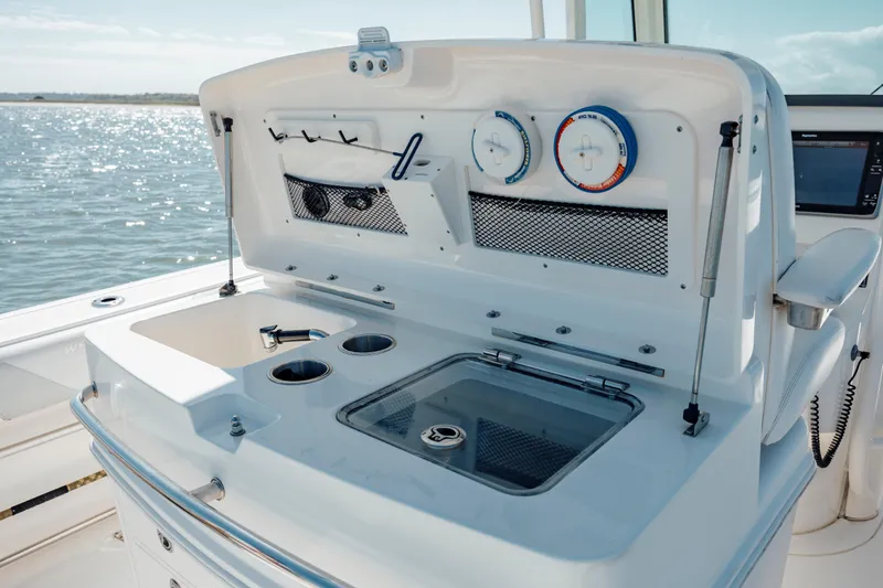 Slide: The Image of 2013 Boston Whaler 320 Outrage boat console with gauges and storage compartments. - 30