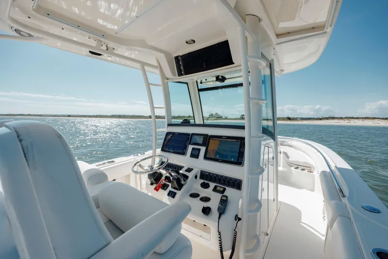 Slide: The Image of 2013 Boston Whaler 320 Outrage boat interior with modern navigation equipment on a sunny day. - 33