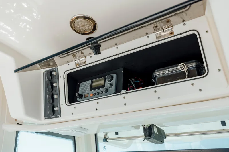 Slide: The Image of 2013 Boston Whaler 320 Outrage electronics compartment with radio and storage. - 37