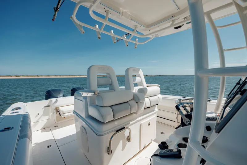 Slide: The Image of 2013 Boston Whaler 320 Outrage boat interior with seating, ocean view, and clear sky. - 38