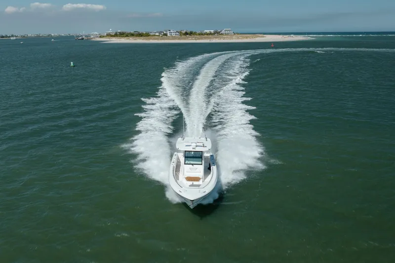 Slide: The Image of 2013 Boston Whaler 320 Outrage cruising on open water near a coastal island. - 4