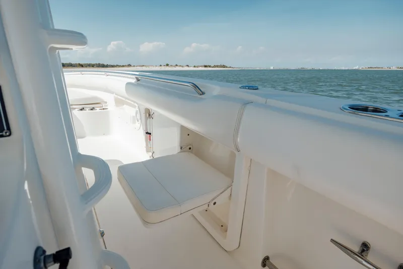 Slide: The Image of 2013 Boston Whaler 320 Outrage interior with seating, ocean view, and clear sky. - 43