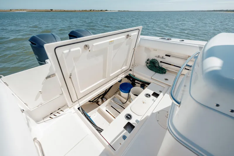 Slide: The Image of 2013 Boston Whaler 320 Outrage boat with open storage compartment on calm water. - 45