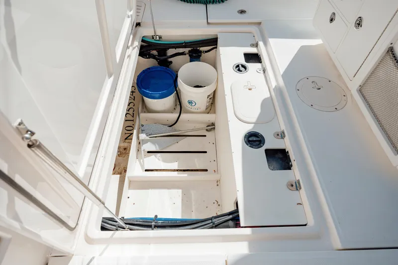 Slide: The Image of 2013 Boston Whaler 320 Outrage deck storage with buckets and equipment. - 46