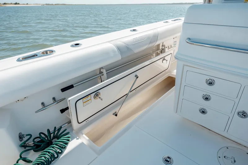 Slide: The Image of 2013 Boston Whaler 320 Outrage interior with storage compartments and ocean view. - 49