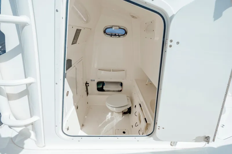 Slide: The Image of Interior of 2013 Boston Whaler 320 Outrage boat, featuring a compact marine toilet. - 50