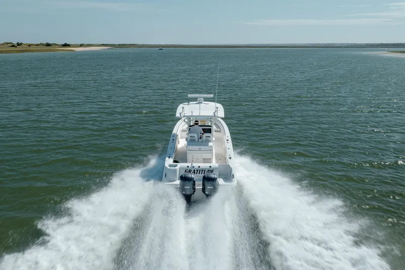 Slide: The Image of 2013 Boston Whaler 320 Outrage cruising on open water, rear view. - 9