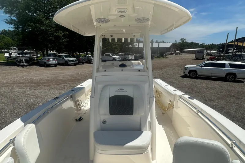 Slide: The Image of 2023 Cobia 262 Center Console boat in a parking lot, showcasing seating and helm. - 19