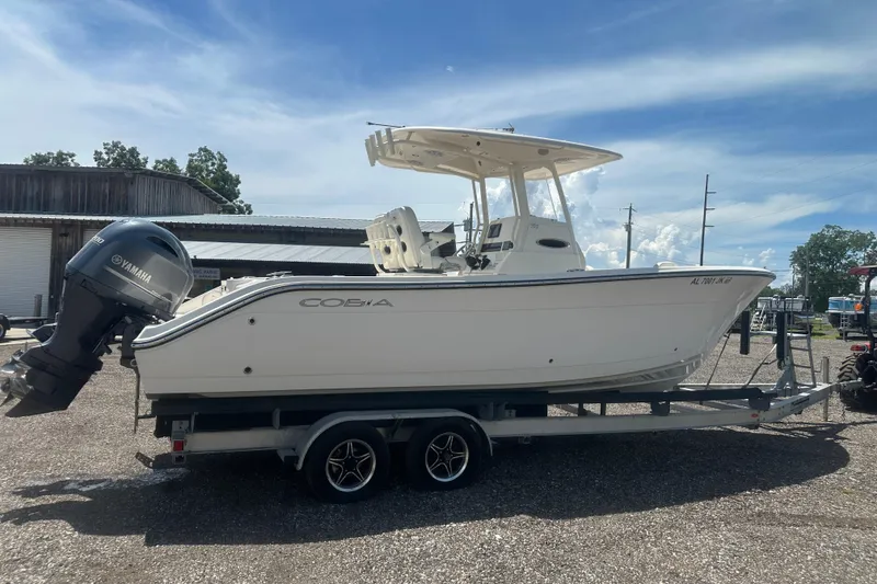 Slide: The Image of 2023 Cobia 262 Center Console boat on trailer with Yamaha engine, outdoor setting. - 2