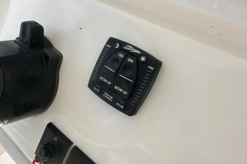 Slide: The Image of Control panel on 2023 Cobia 262 Center Console boat, featuring trim tab controls. - 28