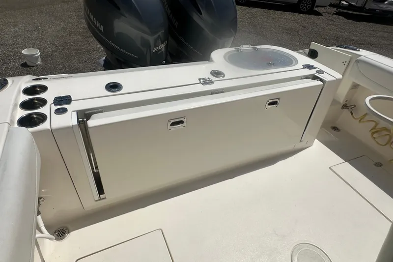 Slide: The Image of 2023 Cobia 262 Center Console boat interior with Yamaha engines and fishing rod holders. - 29