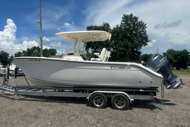 Slide: The Image of 2023 Cobia 262 Center Console boat on trailer under clear blue sky. - 6