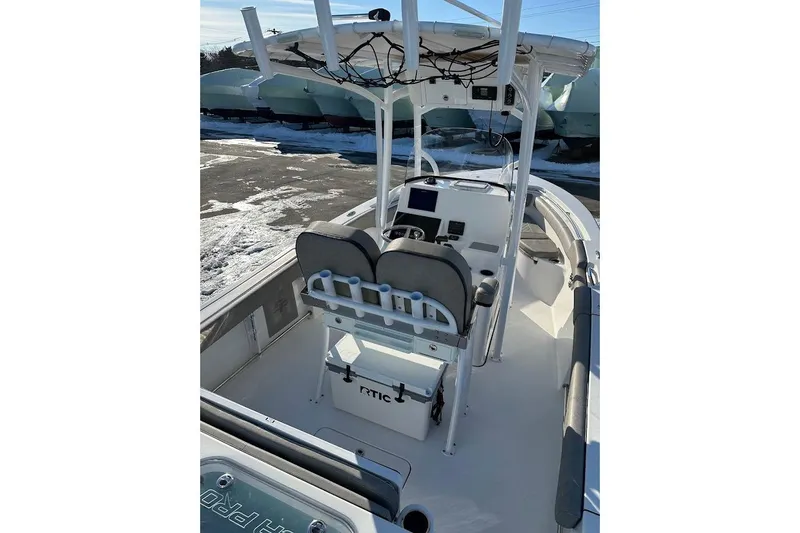 Slide: The Image of 2022 Sea Pro 219 Center Console boat interior with helm and seating, parked on snowy ground. - 14