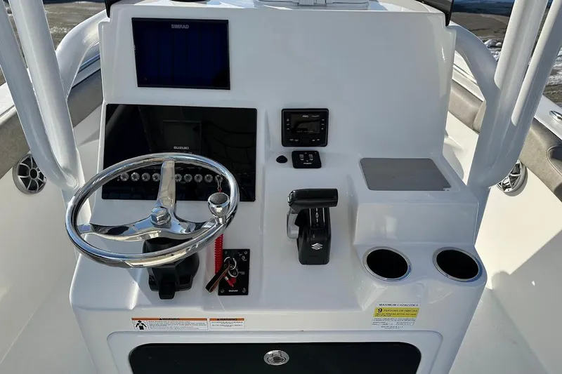 Slide: The Image of 2022 Sea Pro 219 Center Console boat dashboard with steering wheel and controls. - 18