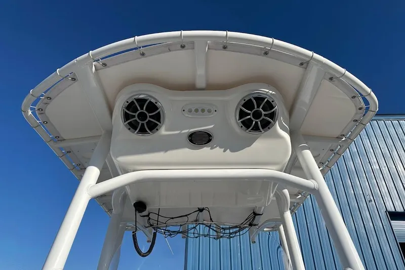 Slide: The Image of 2022 Sea Pro 219 Center Console boat with speakers and canopy against blue sky. - 25