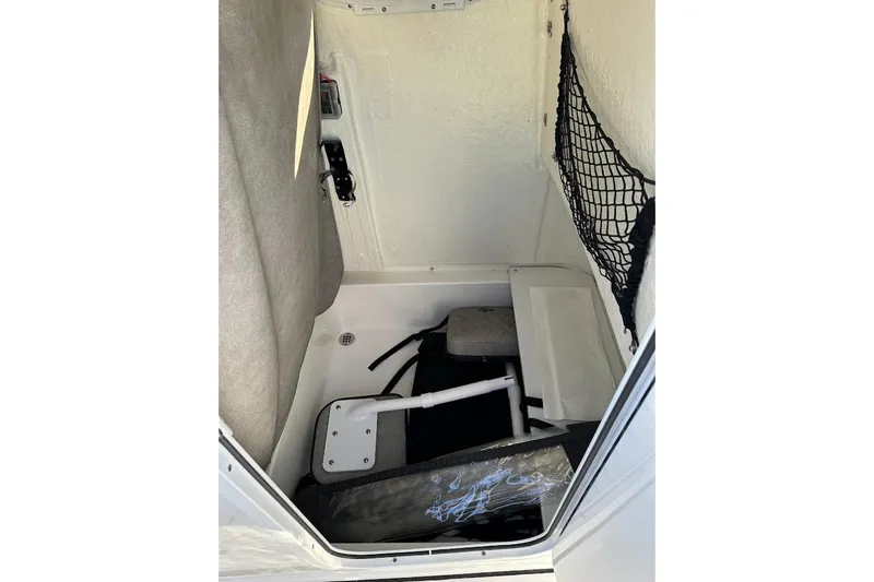 Slide: The Image of 2022 Sea Pro 219 Center Console interior storage compartment with netting and equipment. - 26