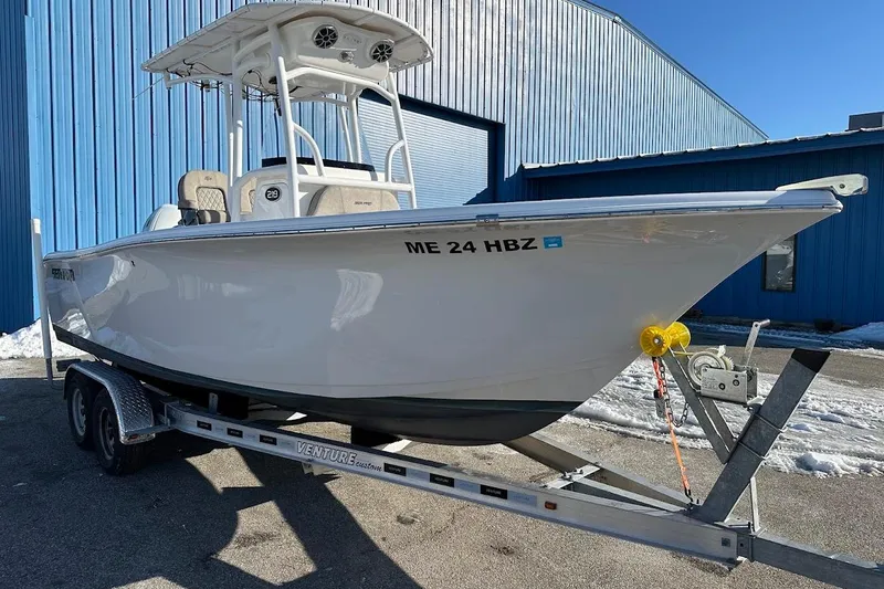 Slide: The Image of 2022 Sea Pro 219 Center Console boat on trailer, parked near blue building. - 4