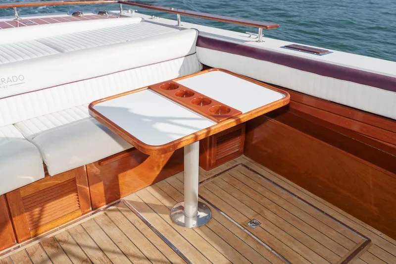 Slide: The Image of Luxurious seating area on a 1991 Windsor Craft 31 Sport Cruiser with wooden table and cup holders. - 10