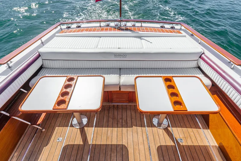 Slide: The Image of 1991 Windsor Craft 31 Sport Cruiser deck with seating and dual tables on water. - 11