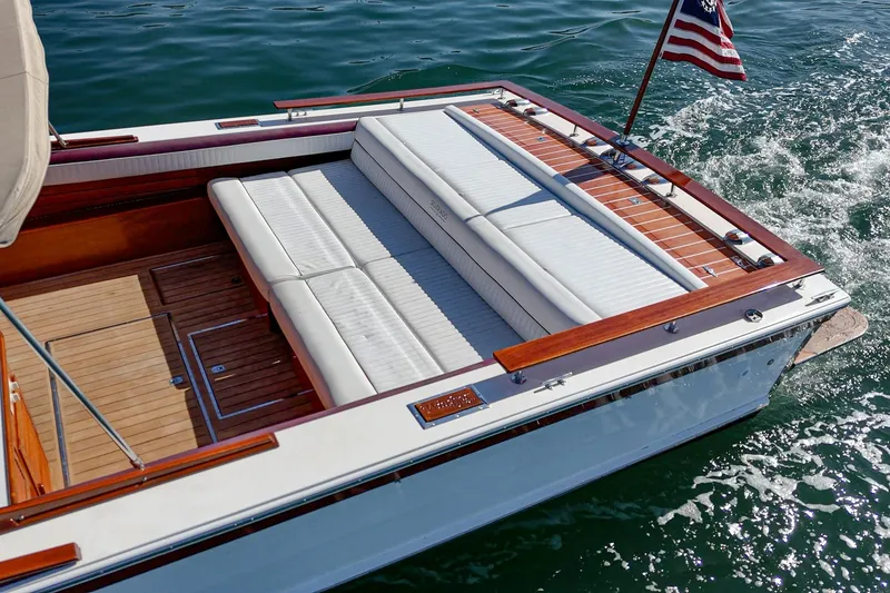 Slide: The Image of 1991 Windsor Craft 31 Sport Cruiser with elegant seating and American flag on water. - 14