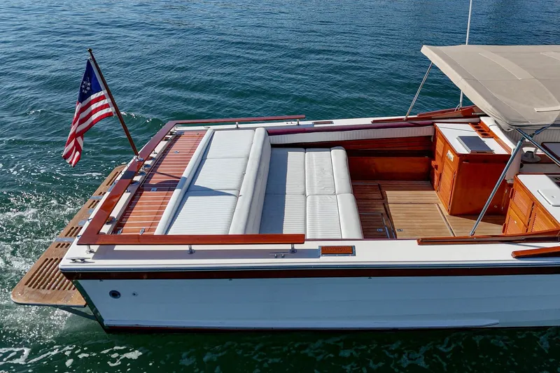 Slide: The Image of 1991 Windsor Craft 31 Sport Cruiser on water, featuring elegant wood and white seating. - 16