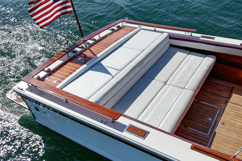 Slide: The Image of 1991 Windsor Craft 31 Sport Cruiser with American flag, elegant seating, and teak deck on water. - 17