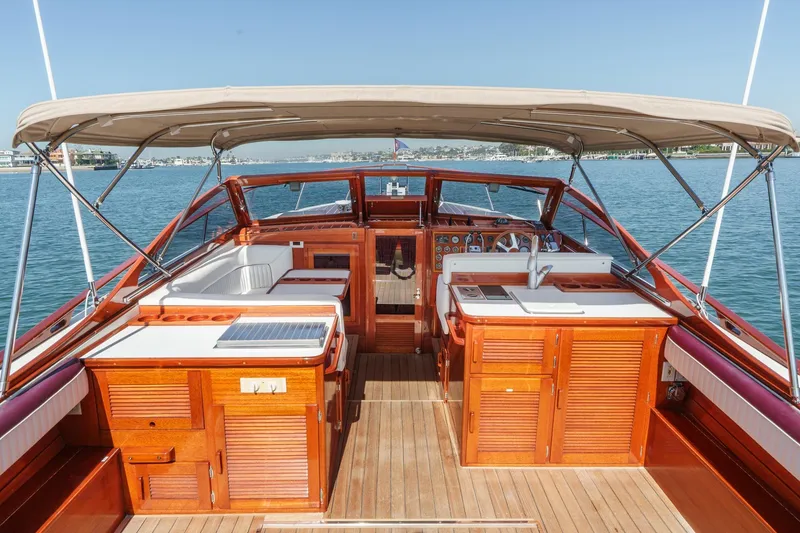 Slide: The Image of 1991 Windsor Craft 31 Sport Cruiser interior with wooden cabinetry and canopy on calm water. - 20