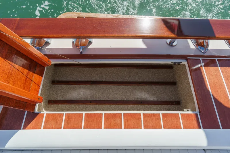 Slide: The Image of Windsor Craft 31 Sport Cruiser 1991 deck detail with wood finish and open storage compartment. - 57