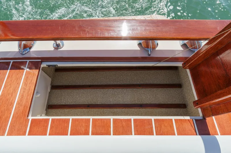 Slide: The Image of 1991 Windsor Craft 31 Sport Cruiser deck with wooden finish and open storage compartment. - 58