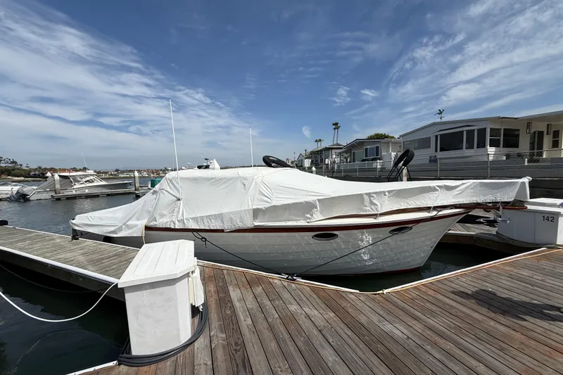 Slide: The Image of 1991 Windsor Craft 31 Sport Cruiser docked, covered with a white tarp, under a clear sky. - 63
