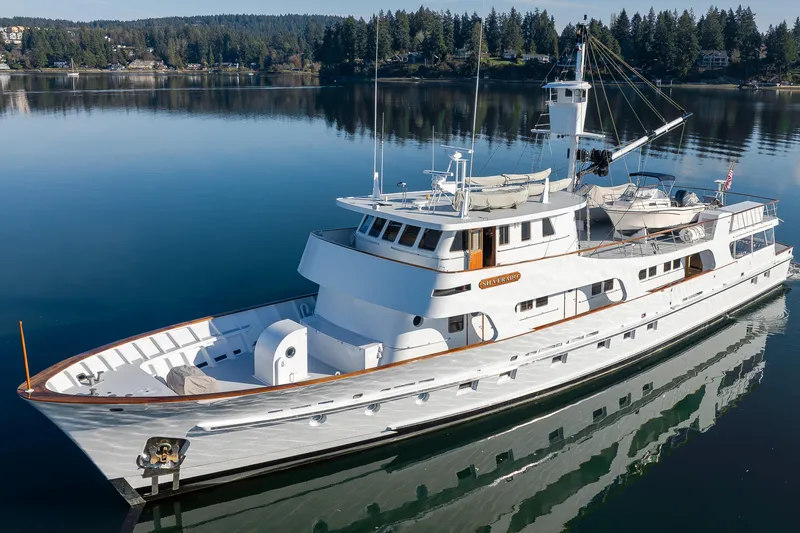 Slide: The Image of Vintage 1974 Willard 1201 yacht on serene lake with forested shoreline. - 12