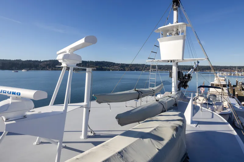 Slide: The Image of 1974 Willard 1201 yacht deck with radar equipment, docked by a scenic waterfront. - 17