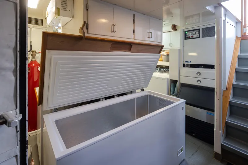 Slide: The Image of 1974 Willard 1201 interior with open freezer, storage cabinets, and stairs. - 23