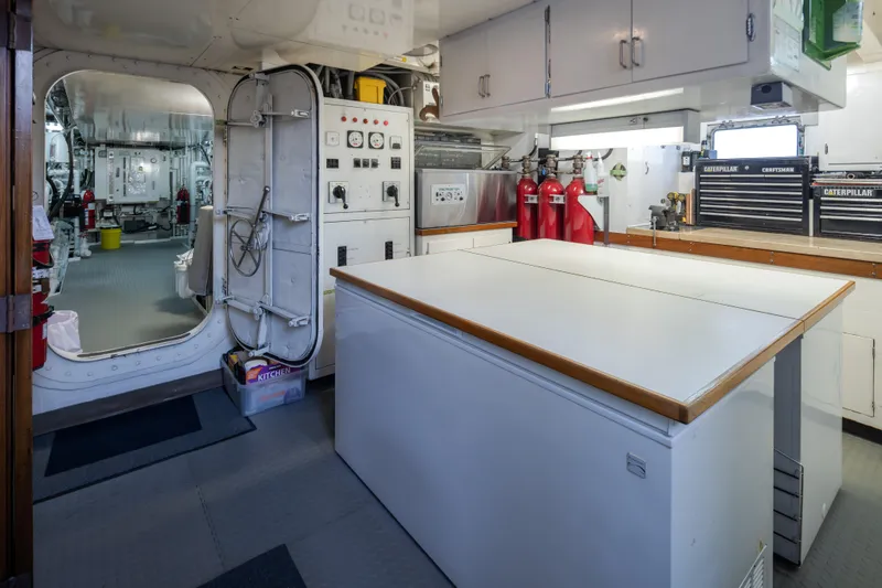 Slide: The Image of Engine room of a 1974 Willard 1201 vessel with control panels and workbench. - 25