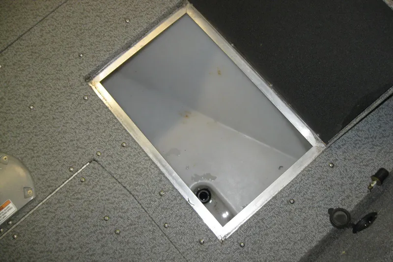 Slide: The Image of 2016 Lund 1775 Impact SS boat interior storage compartment with gray carpeted flooring. - 14