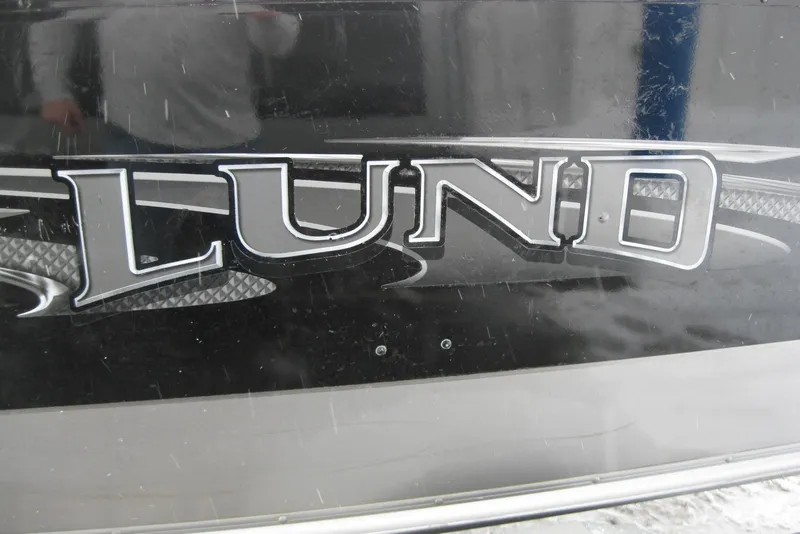 Slide: The Image of 2016 Lund 1775 Impact SS boat logo on black surface. - 2