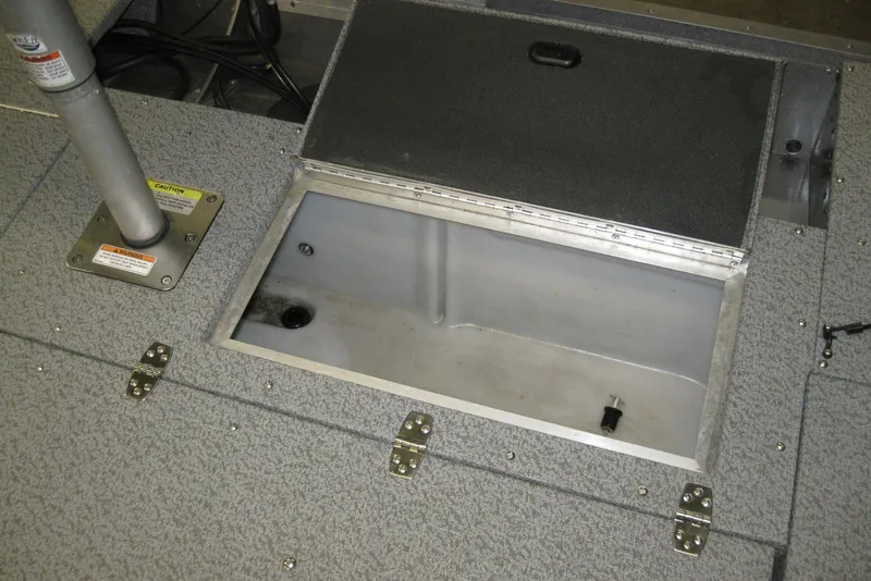 Slide: The Image of 2016 Lund 1775 Impact SS boat storage compartment with open lid and gray interior. - 7