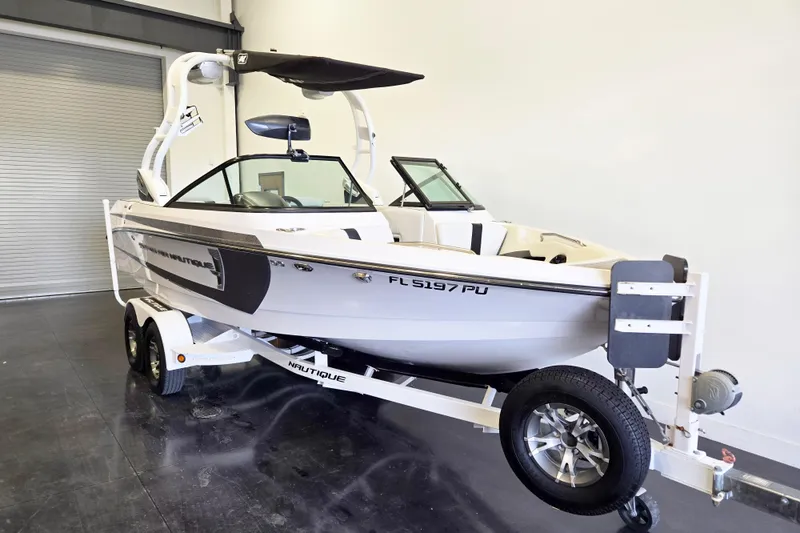 Slide: The Image of 2014 Nautique Super Air Nautique 210 boat on trailer in indoor setting. - 20