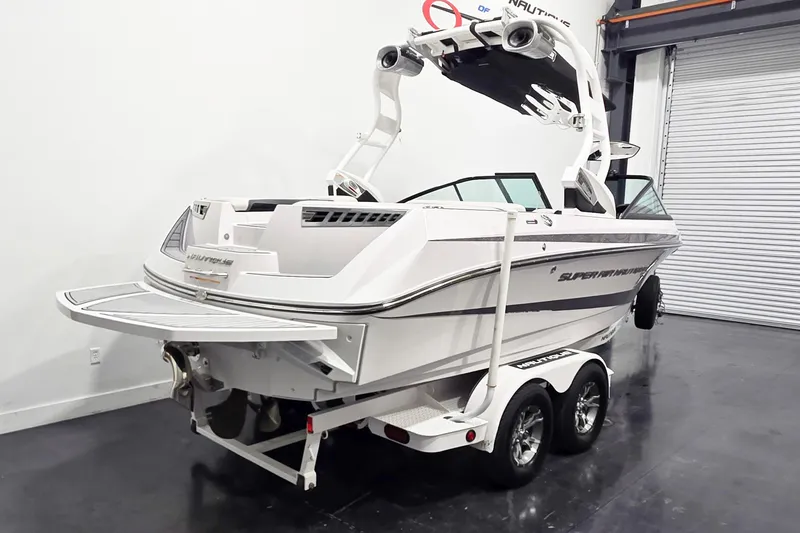 Slide: The Image of 2014 Nautique Super Air Nautique 210 boat on trailer in indoor storage. - 21